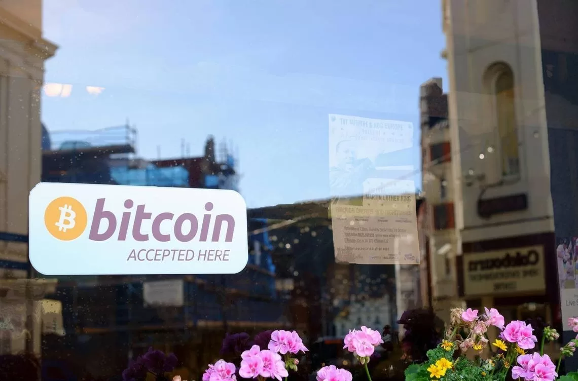 'Bitcoin wordt hier geaccepteerd' sticker op een raam van 'The Thirsty Pigeon' bar in Douglas, Isle of Man